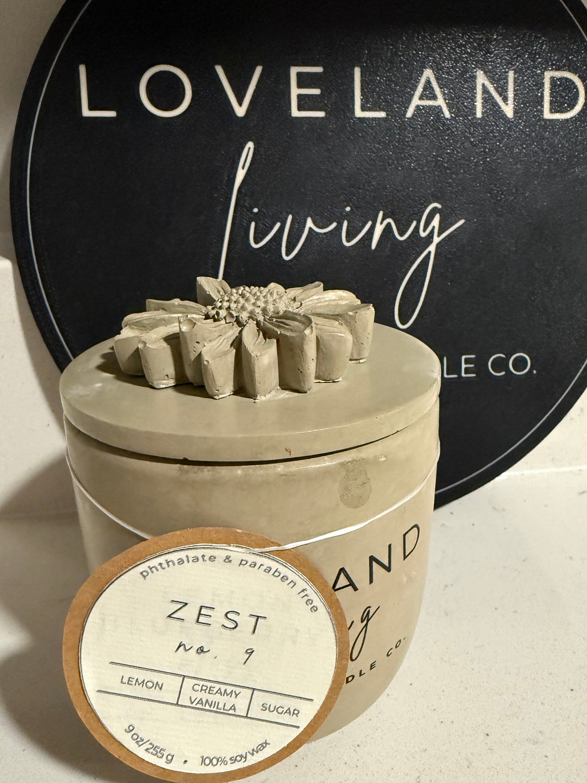 Ceramic container with 'Zest' label on a textured surface, with 'Loveland Living' logo in the background.