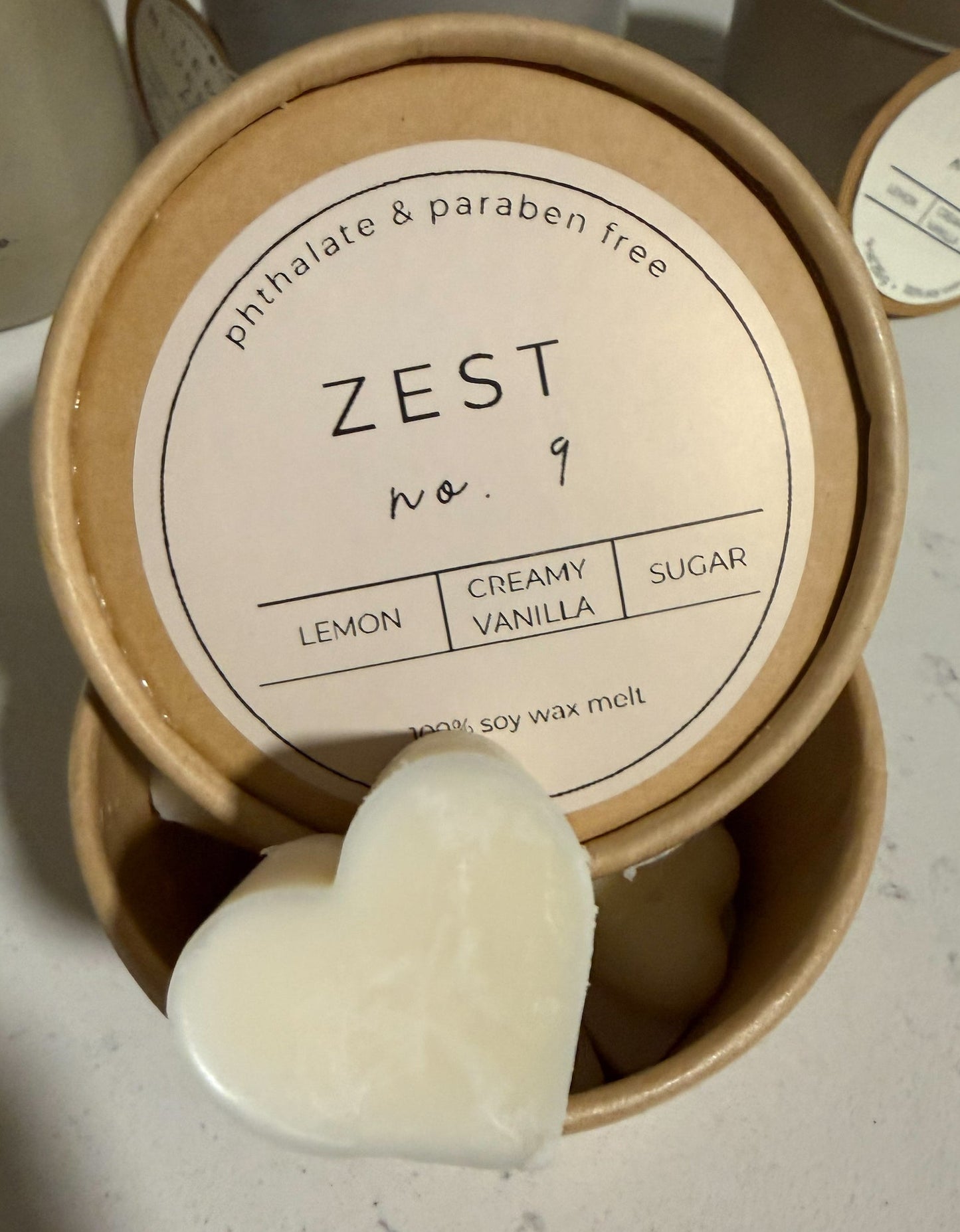Scented wax melt packaging with 'ZEST' branding on a light surface.